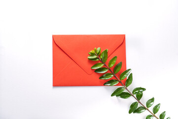 red envelope and green sprigs on white background