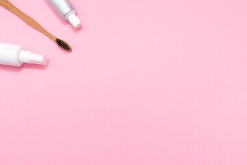 Eco and hygiene. A bamboo toothbrush, mouth freshener and toothpaste. Flat lay. Pink background. Copy space. The concept of eco-friendly hygiene tools