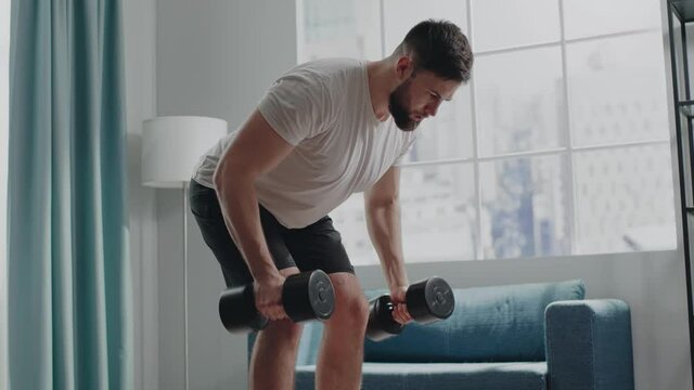 Muscular bodybuilder with beard practices morning workout