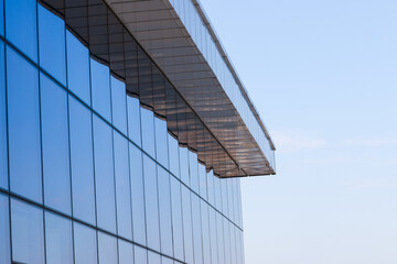 Fragment of the new, modern building with windows and blue stained-glass windows.