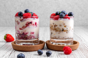 Muesli with yoghurt and berries in glasses on cork coasters. Healthy food concept. High quality photo