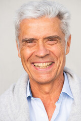 Fototapeta na wymiar headshot smiling older man against white background