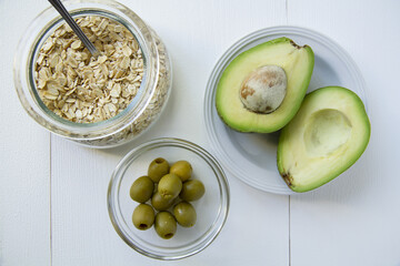 Avocado, two parts sliced, hercules cereals and olives for healthy breakfast or diet, flat lay, horizontal 