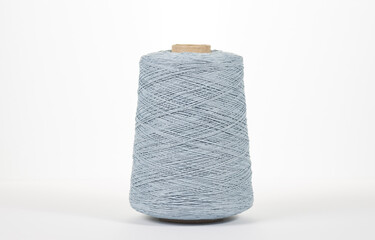Gray spool of yarn on a white background. Side view. Textile spool on an isolated white background.