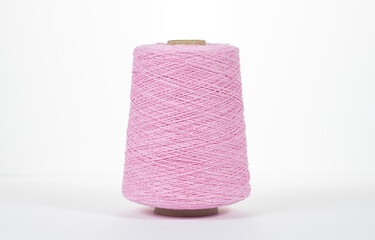 Close-up of a pink bobbin with cotton thread on a white background.