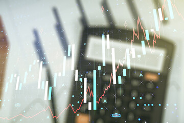 Double exposure of abstract creative financial chart hologram on blurry calculator background, research and strategy concept