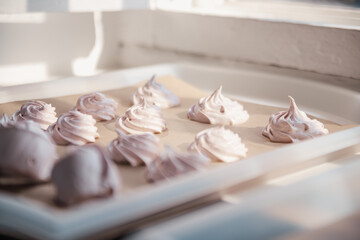 Homemade marshmallows on parchment paper dries in the sun on a baking sheet. Homemade sweets, comfort, handmade