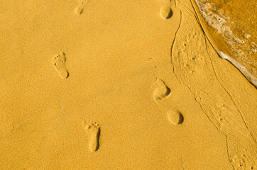 Fototapeta na wymiar Foot prints on the beach sand. Flight vacation concept.
