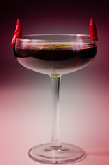 Cocktail drink prepared with vodka, grenadine and lemon juice decorated with bird eye chillies in the shape of horns