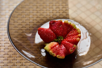 A large ripe strawberry with original unusual shape. The strawberry looks like a seashell 
