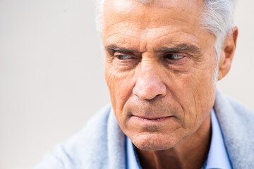 Close up serious older man face with eyes glancing away