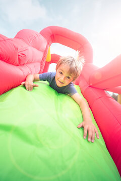 Child On Inflatable Bouncy Castle Slide