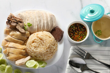 Top view Steamed chicken rice with chilli sauce and soup on white table background. Asia foods concept.