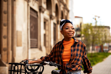 Happy young woman riding bicycle in the city. Woman enjoying outdoors