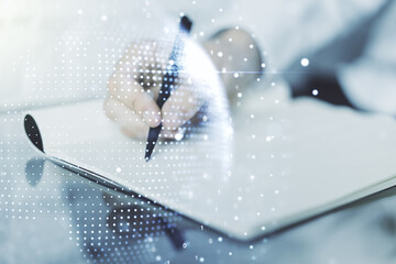 Abstract creative digital world map and man hand writing in diary on background, globalization...