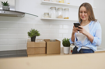 Women communicate via smartphone after moving to new flat.