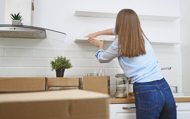 Woman wipes the kitchen after moving to new apartment.