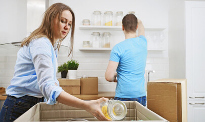 Family couple unpacking boxes after moving to new apartment.