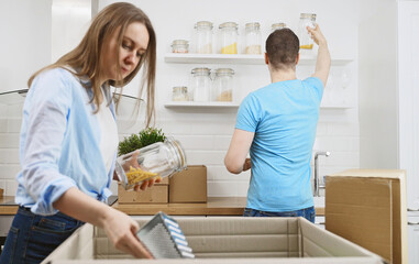 Family couple unpacking boxes after moving to new apartment.