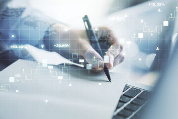 Multi exposure of abstract creative financial graph with world map and with hand writing in notebook on background with laptop, forex and investment concept