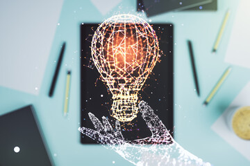 Creative light bulb hologram and modern digital tablet on background, idea concept. Multiexposure