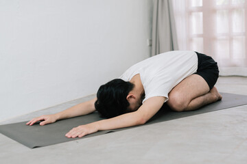 Fototapeta na wymiar Asian young man doing yoga at home
