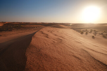 Sunset over the sand dunes in the desert.