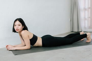 Fototapeta na wymiar Young asian woman doing sport exercises indoor at home