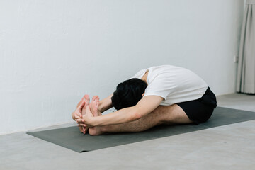 Fototapeta premium Asian young man doing yoga at home