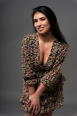Beautiful plus size hispanic young woman on gray