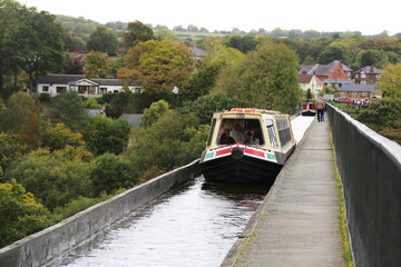A canal boat navigating the Llangollen canal across the Pontcysyllte aqueduct in the Dee Valley.