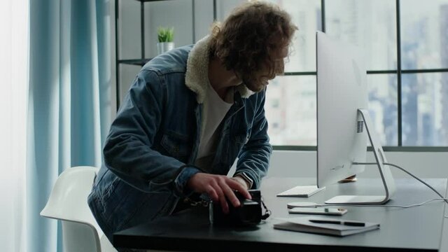 Freelance worker puts camera on desk and works on computer