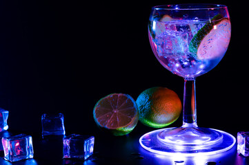 Gin Tonic cocktail in a glass with a lime and ice cubes