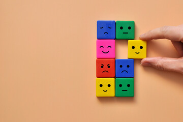 Colorful cubes with drawings of various emotions: sadness, anger, calmness. Emotions in a person's...