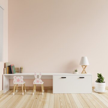 Children's room with cream colored walls is blank. There were books, colored pencils and lamps on the table and a chair and a tree on the floor.3d rendering.