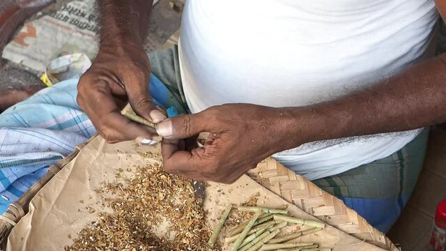 A closeup of an Indian man making beedi outdoors shot in HD