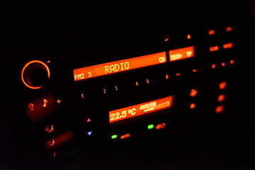Modern car radio illuminated with orange color
