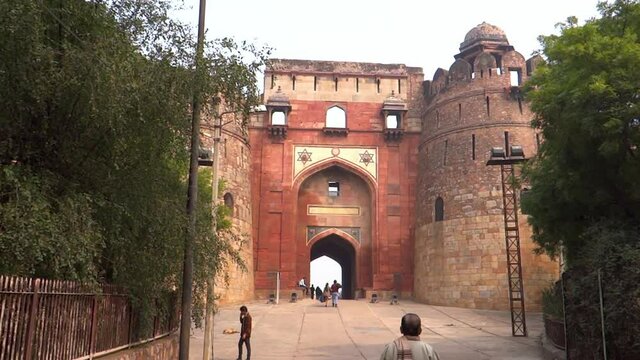 People visiting Purana Qila fort, going through gate