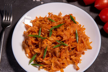 Stewed cabbage with onions and tomatoes is one of the most popular dishes. Homemade stewed cabbage with tomatoes and spices. View from above