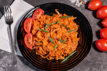 Stewed cabbage with onions and tomatoes is one of the most popular dishes. Homemade stewed cabbage with tomatoes and spices. View from above