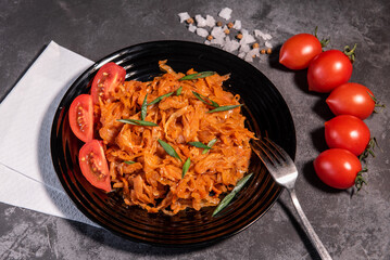 Stewed cabbage with onions and tomatoes is one of the most popular dishes. Homemade stewed cabbage with tomatoes and spices. View from above