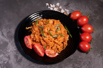 Stewed cabbage with onions and tomatoes is one of the most popular dishes. Homemade stewed cabbage with tomatoes and spices. View from above