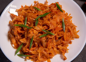 Stewed cabbage with onions and tomatoes is one of the most popular dishes. Homemade stewed cabbage with tomatoes and spices. View from above