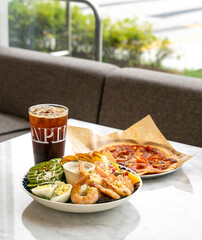 Coffee, pizza and salad are on marble dinning table