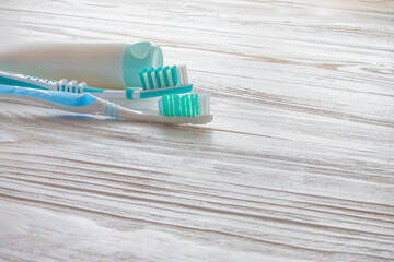 Toothbrushes and toothpaste on a white wooden table. Blue Tooth Cleaning Accessories