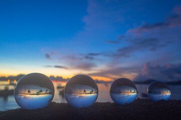 .The 4 glass balls are arranged from large to small placed on the beach at sunrise. .To see the sea...