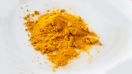 Close view of a bunch of curry powder on top of a white surface