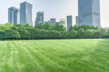 Obraz premium Lujiazui central park, green grass and modern skycrapers, for background.