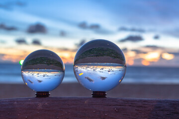 Fototapeta na wymiar sunset sunrise view inside crystal ball..The natural view of the sea and sky are unconventional and beautiful. .A image for a unique and creative travel idea.