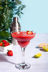 Cold strawberry margarita or daiquiri cocktail with lime and rum